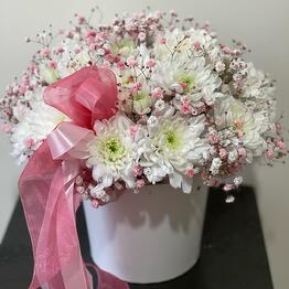 Bouquet of chrysanthemums and gypsophila in a hatbox