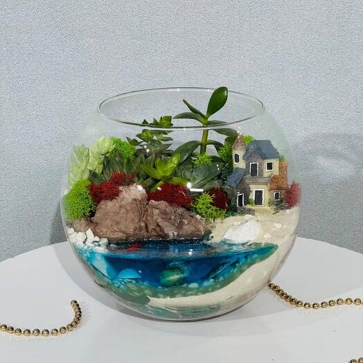 Флорариум с живыми цветами скалами и домом на берегу моря