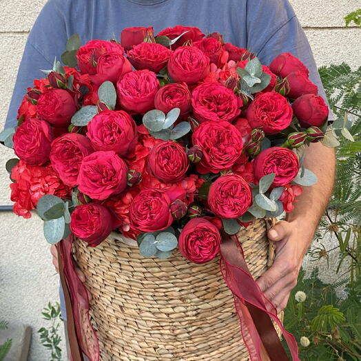 Basket with peony roses, hydrengeas and eucalyptus