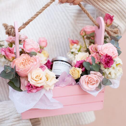 Delicate floral arrangement in a box with an aromatic candle