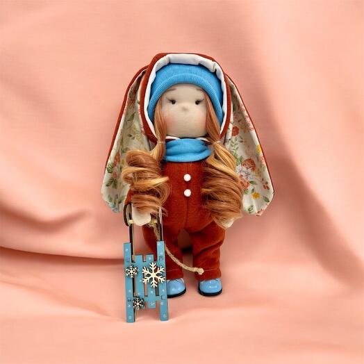 Handmade textile doll with a sled