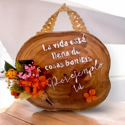 Rodaja de madera con flores secas y frase inspiradora