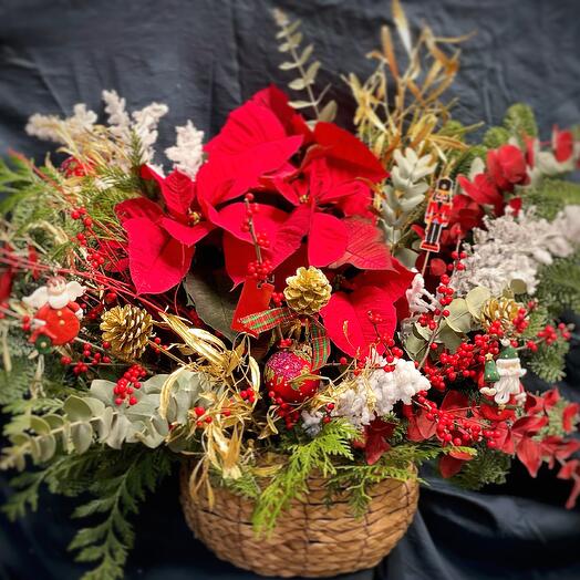 Cesta con poinsettia, verdes de Navidad y adornos navidenos