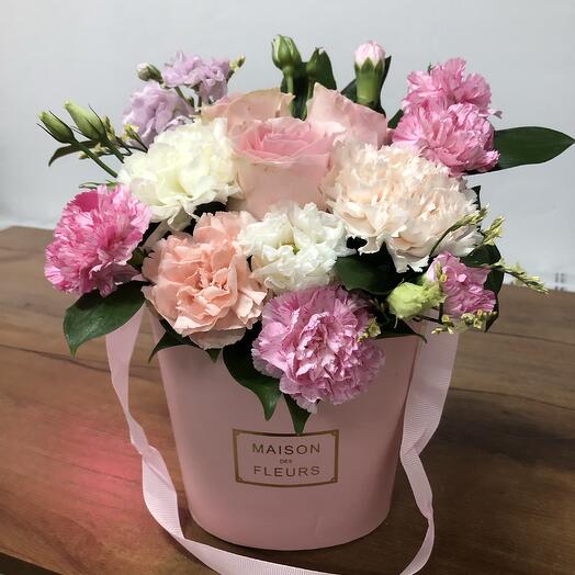 A composition in a box with roses and carnations