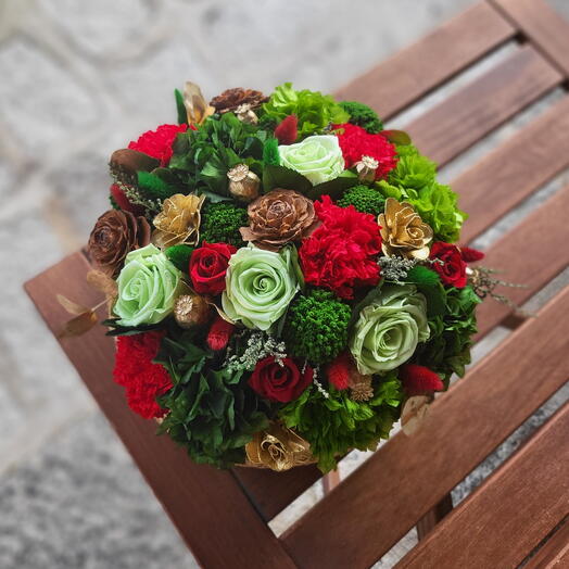 Cesta con flores preservadas en verdes y rojos