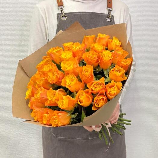 A bouquet of 31 orange roses wrapped in craft paper.