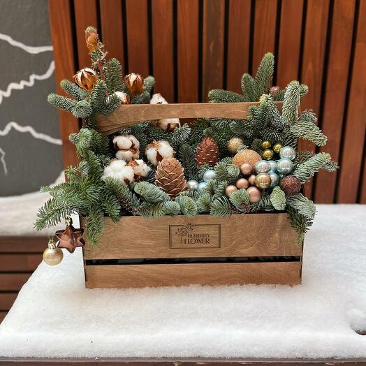 New Year's composition of nobilis spruce, cotton and New Year's decor in a wooden box "Snow-covered forest"